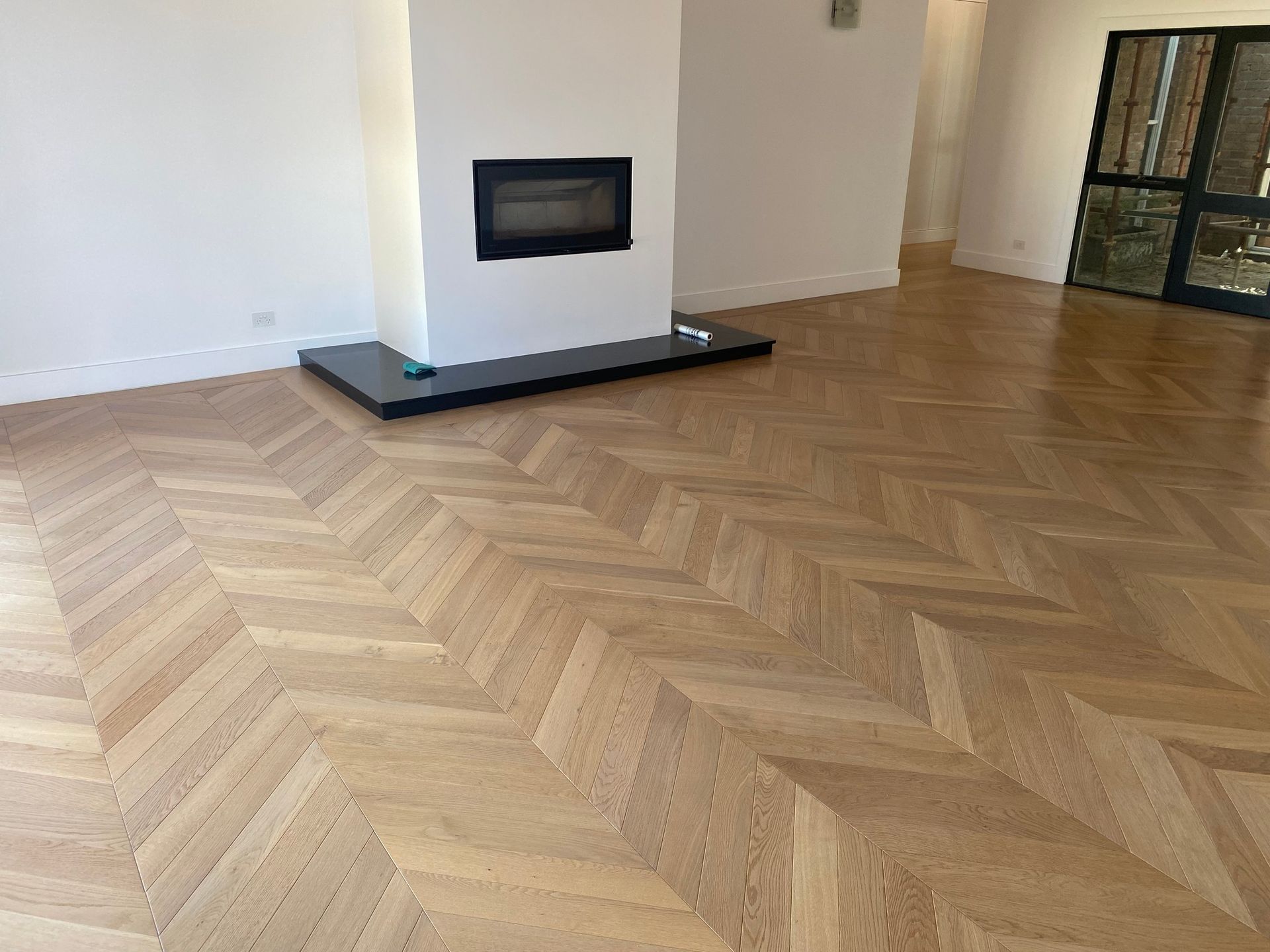 A Living Room With A Wooden Floor And A Fireplace — Flooring Suppliers in Port Macquarie, NSW