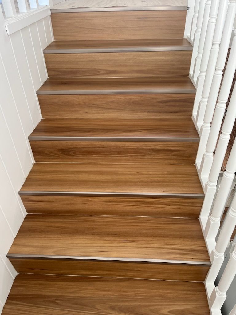 A Set Of Wooden Stairs With A White Railing — Flooring Suppliers in Port Macquarie, NSW