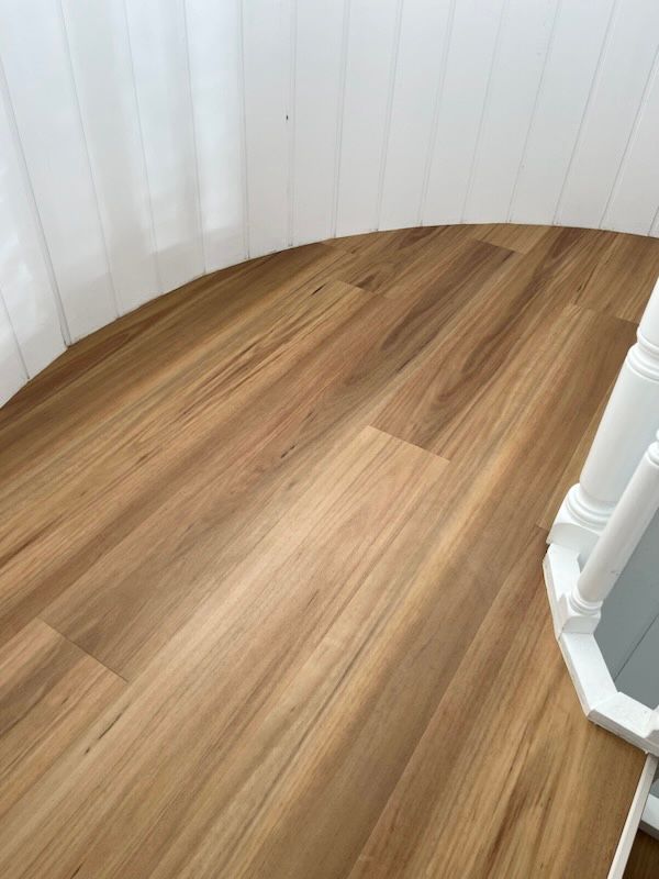 A Close Up Of A Wooden Floor Next To A Staircase — Flooring Suppliers in Port Macquarie, NSW