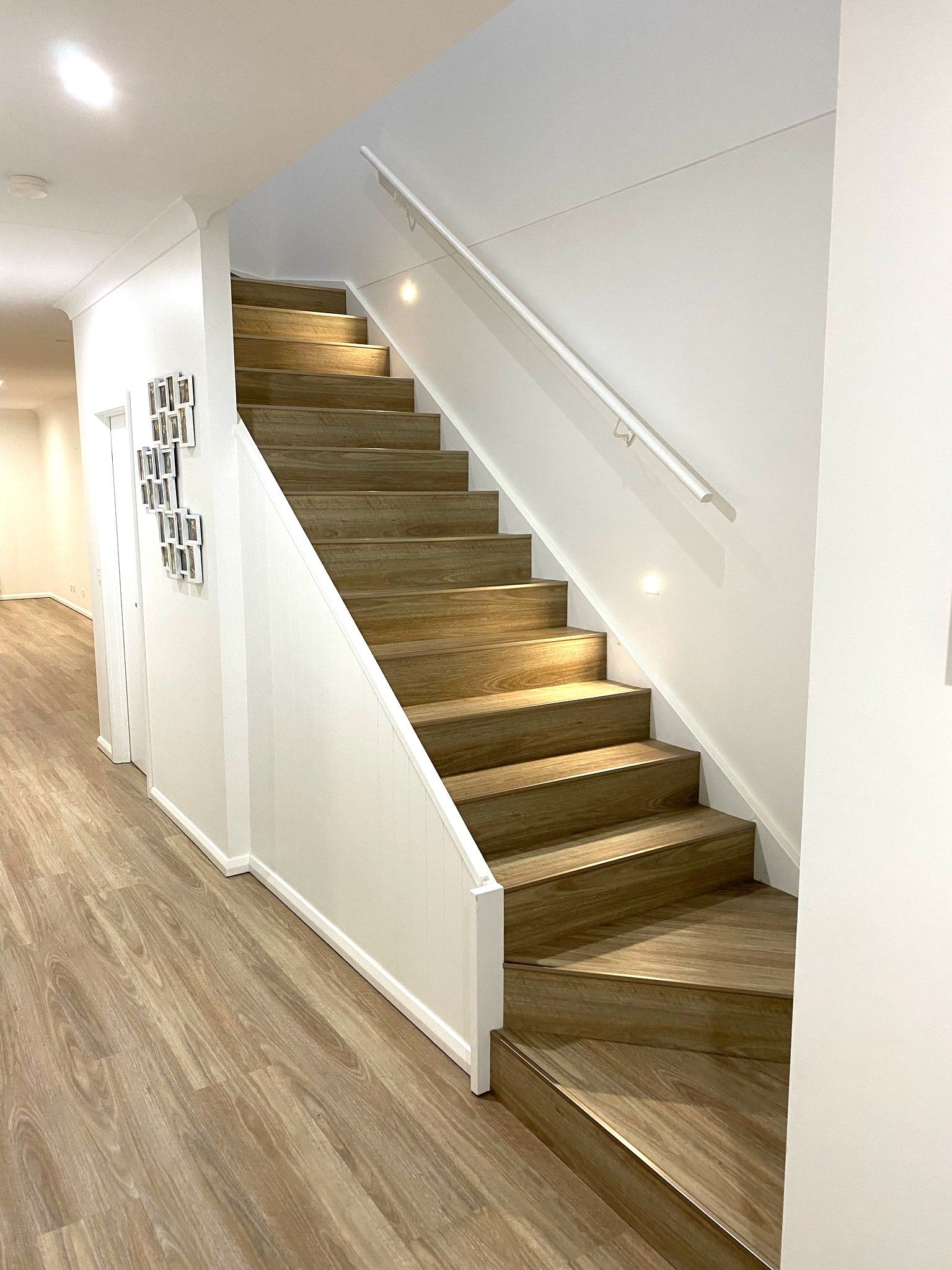 A Staircase With Wooden Steps And A White Railing In A Hallway — Flooring Suppliers in Port Macquarie, NSW