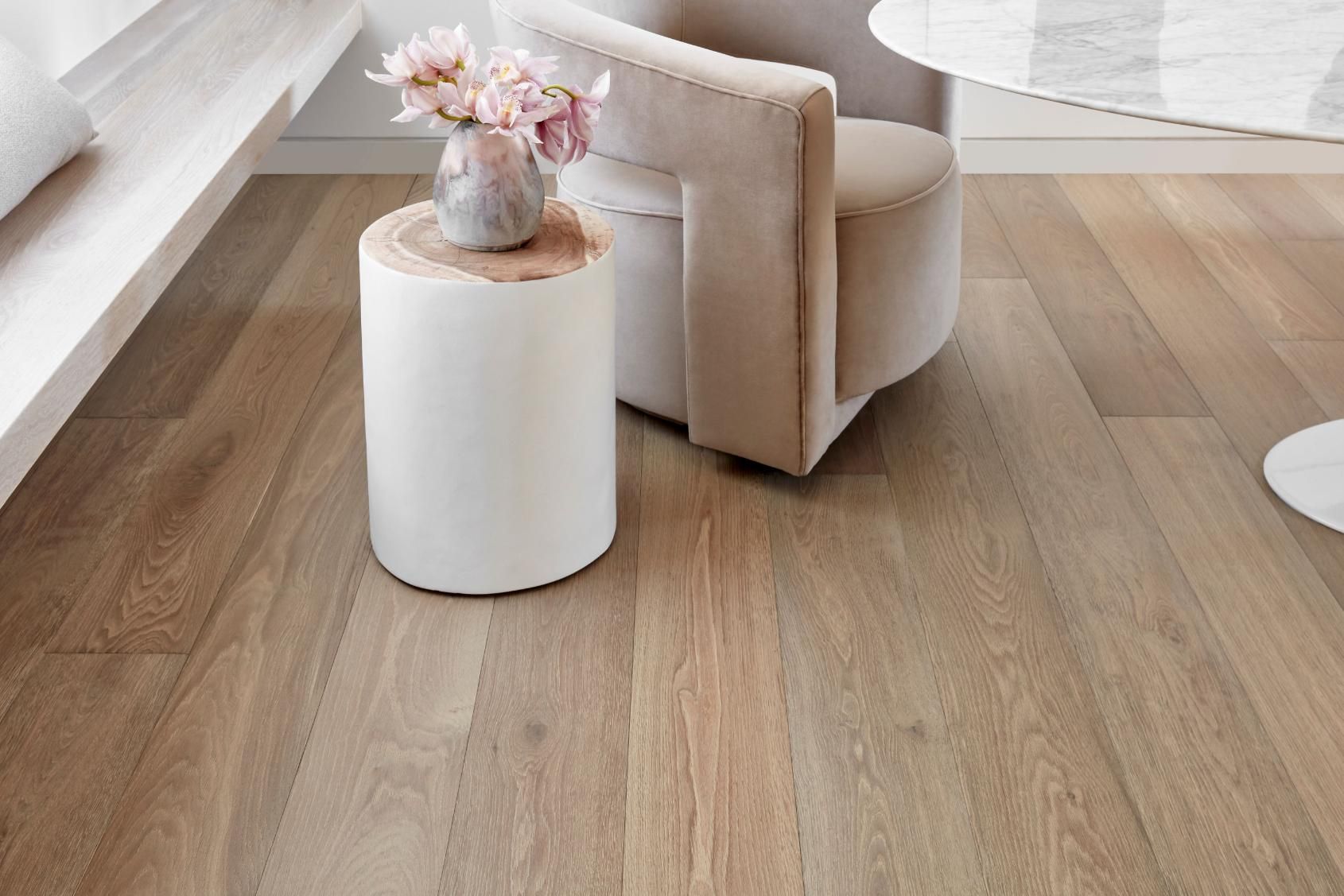 A Wooden Floor In A Living Room With A Sofa and Flower Pot — Flooring Suppliers in Port Macquarie, NSW