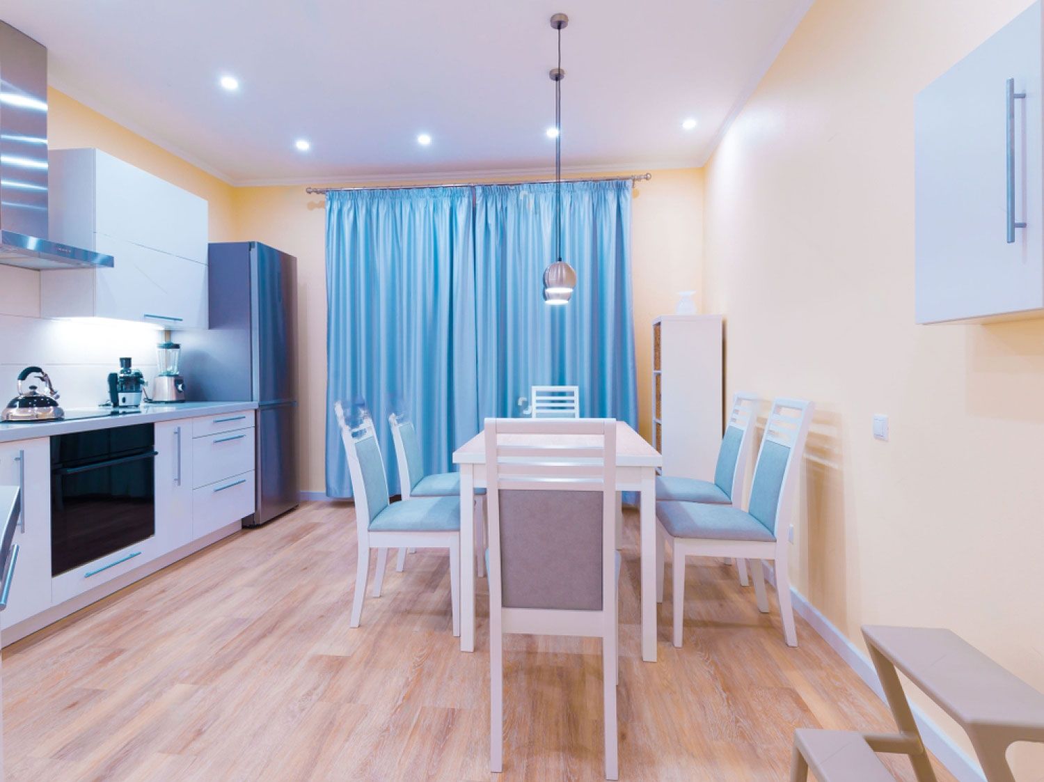 Kitchen with dining table set and blue curtains — Floor Coverings in Harrington, NSW