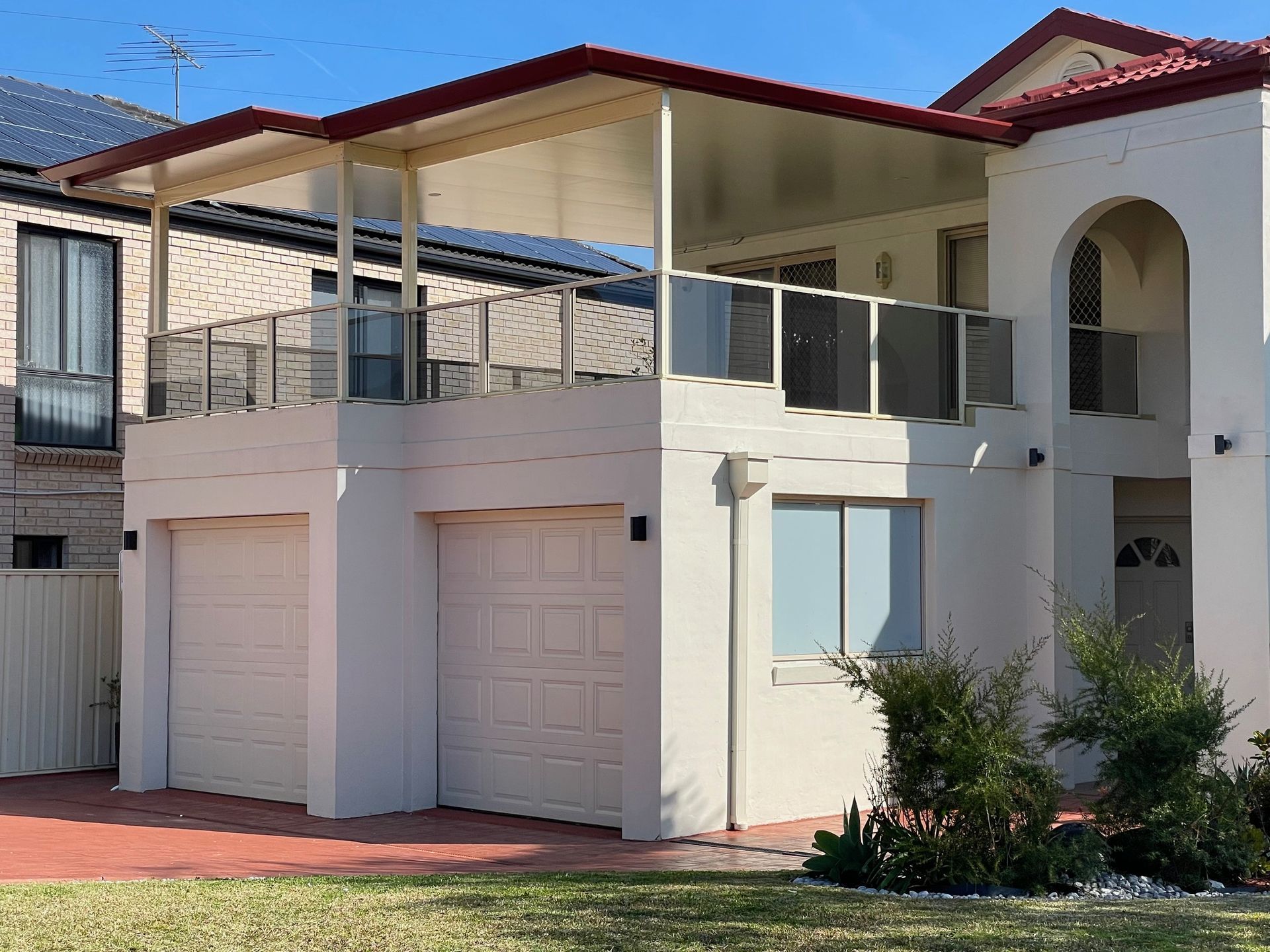 Two-story house with white garage doors and a balcony — Narellan Home Improvement Centre In Narellan, NSW