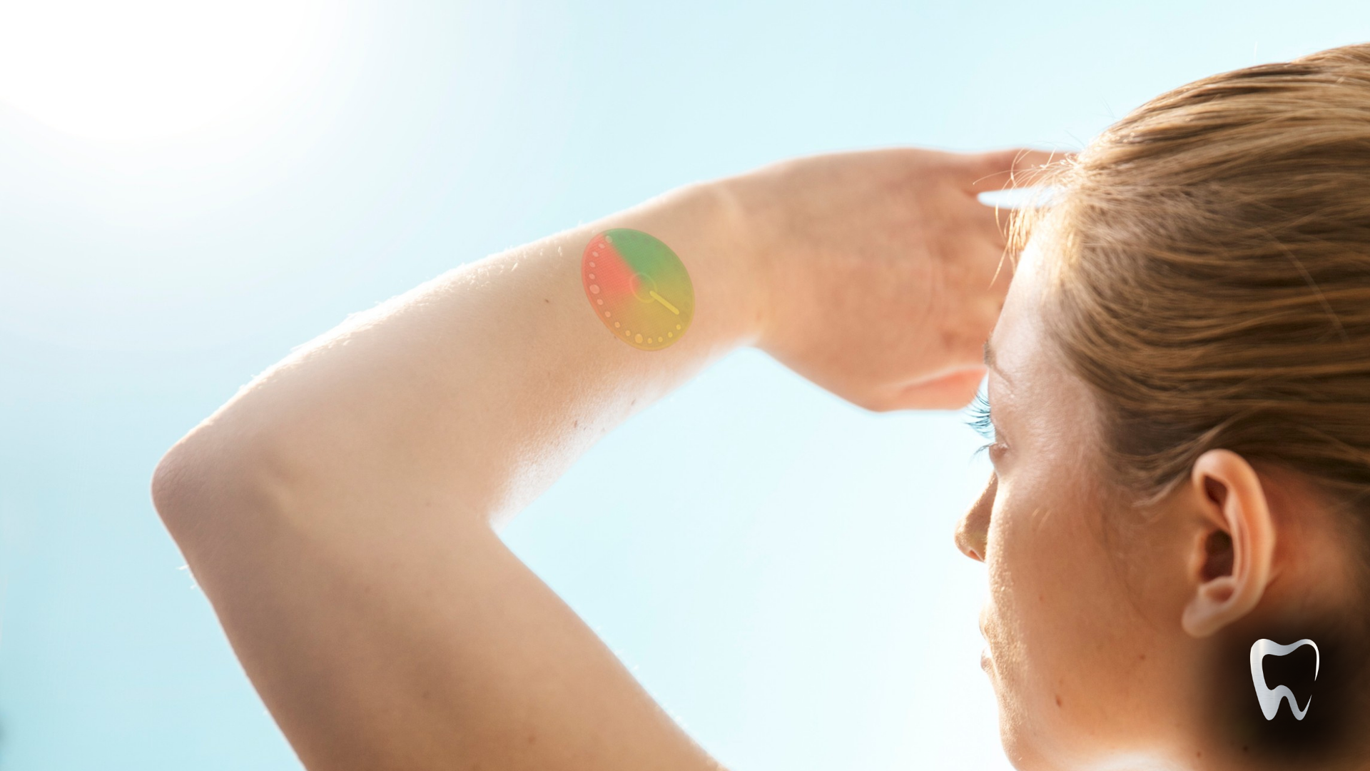 A woman with a tattoo on her arm is covering her eyes from the sun.