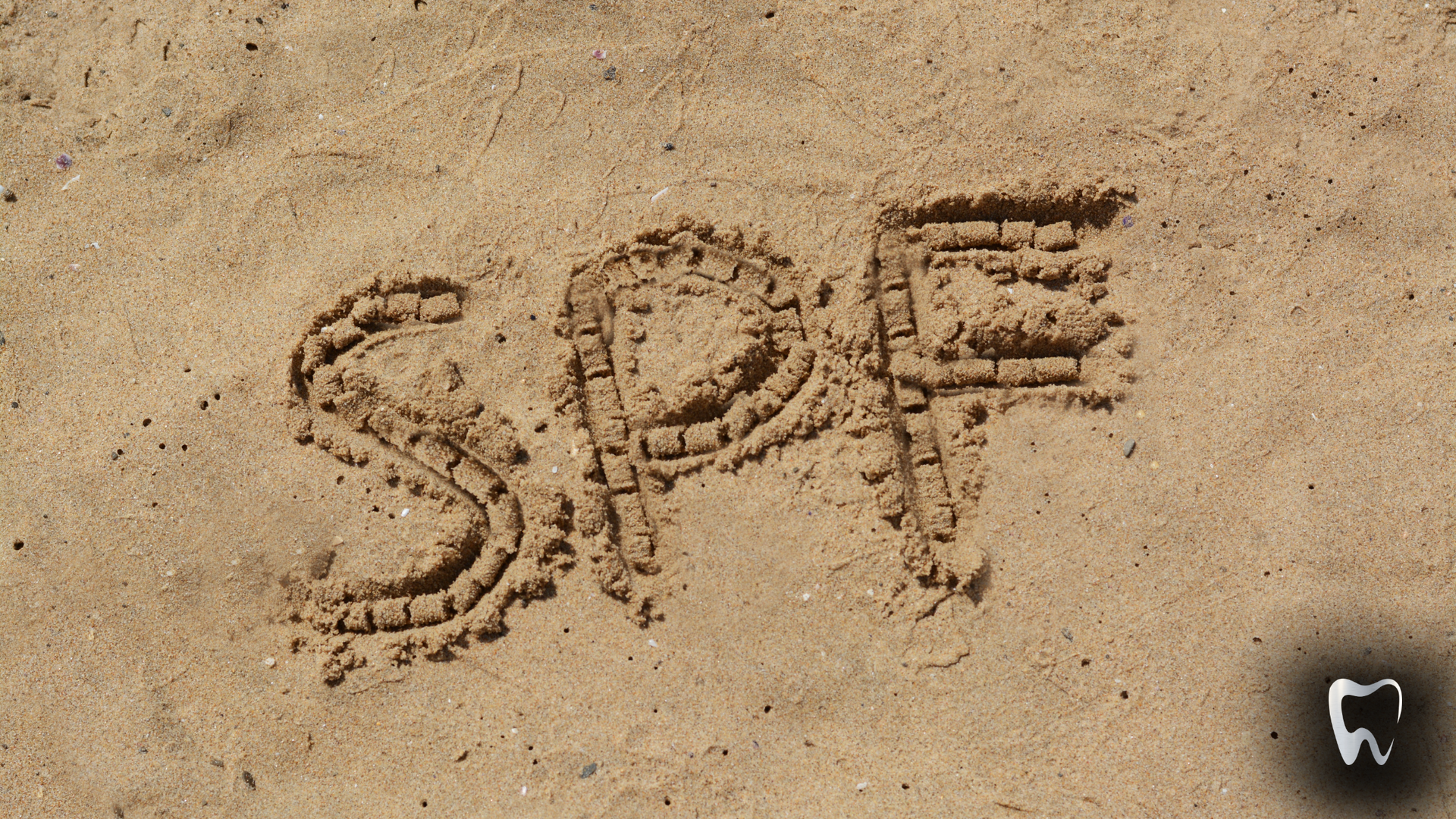 The word spf is written in the sand on a beach