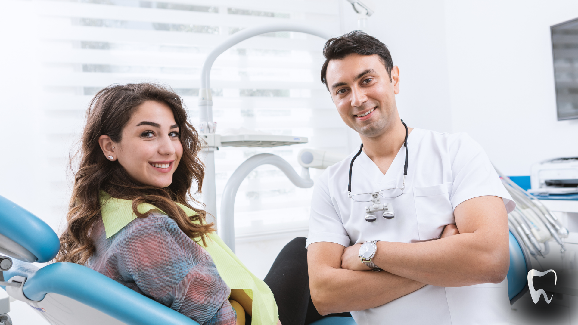 Smiling dentist and patient in dental chair, clinic.