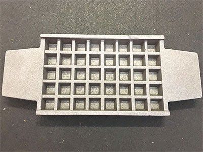 A metal tray with squares on it is sitting on a table.