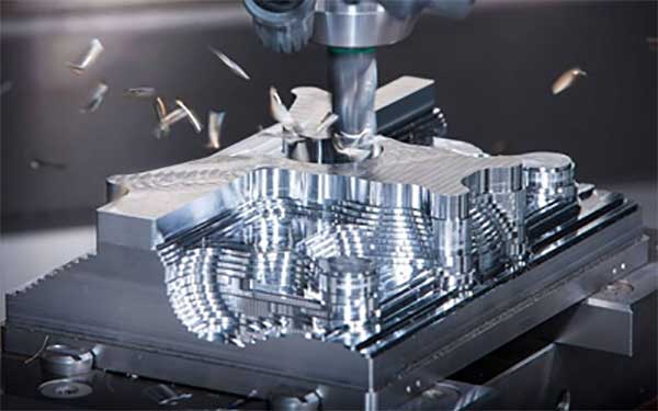 A machine is cutting a piece of metal on a table.