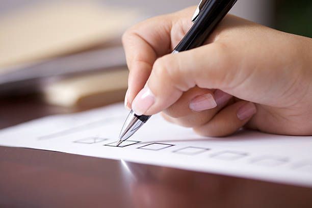 A person is writing on a piece of paper with a pen.