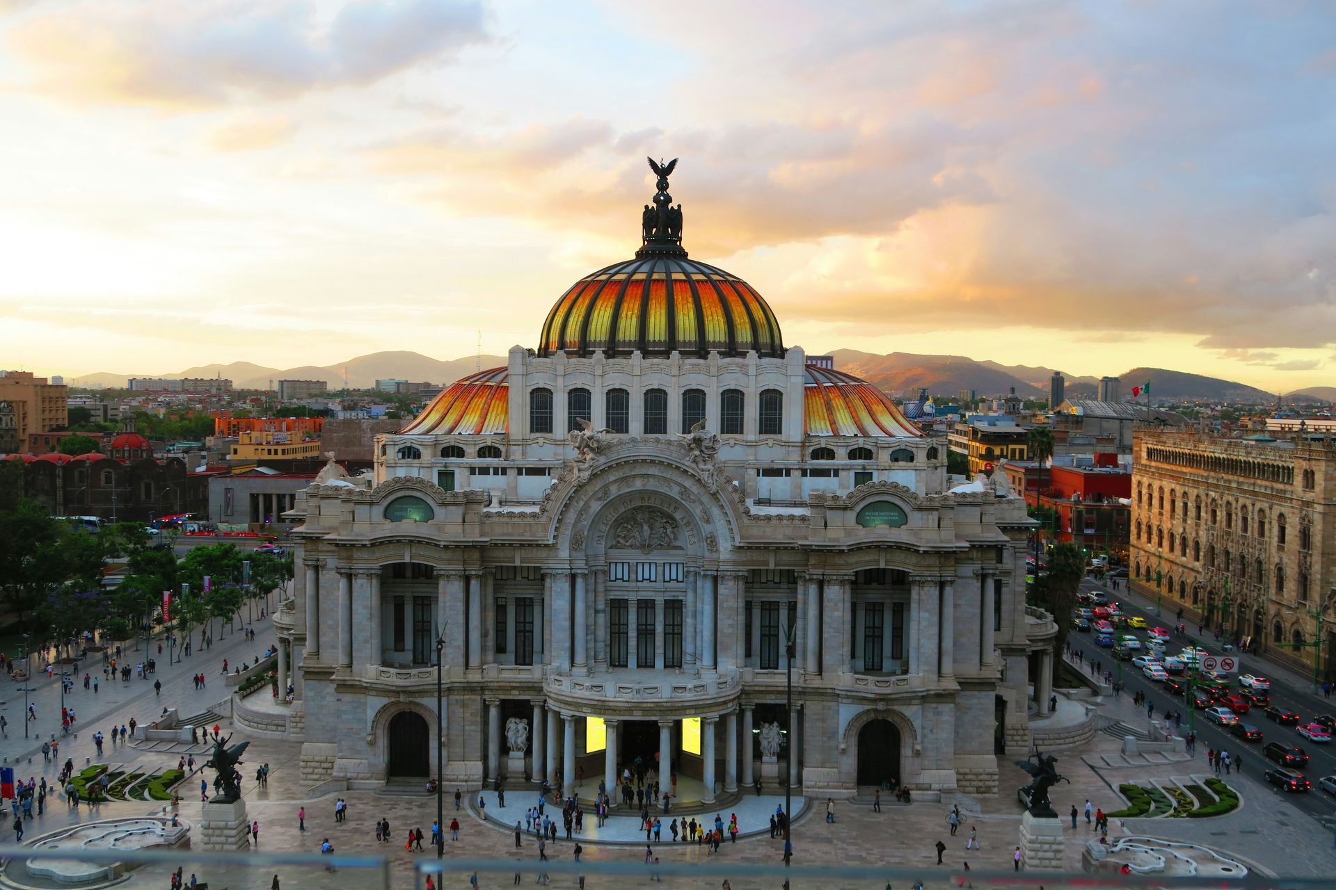 Palais des Beaux-Arts de Mexico au coucher du soleil ; dôme doré et orange.