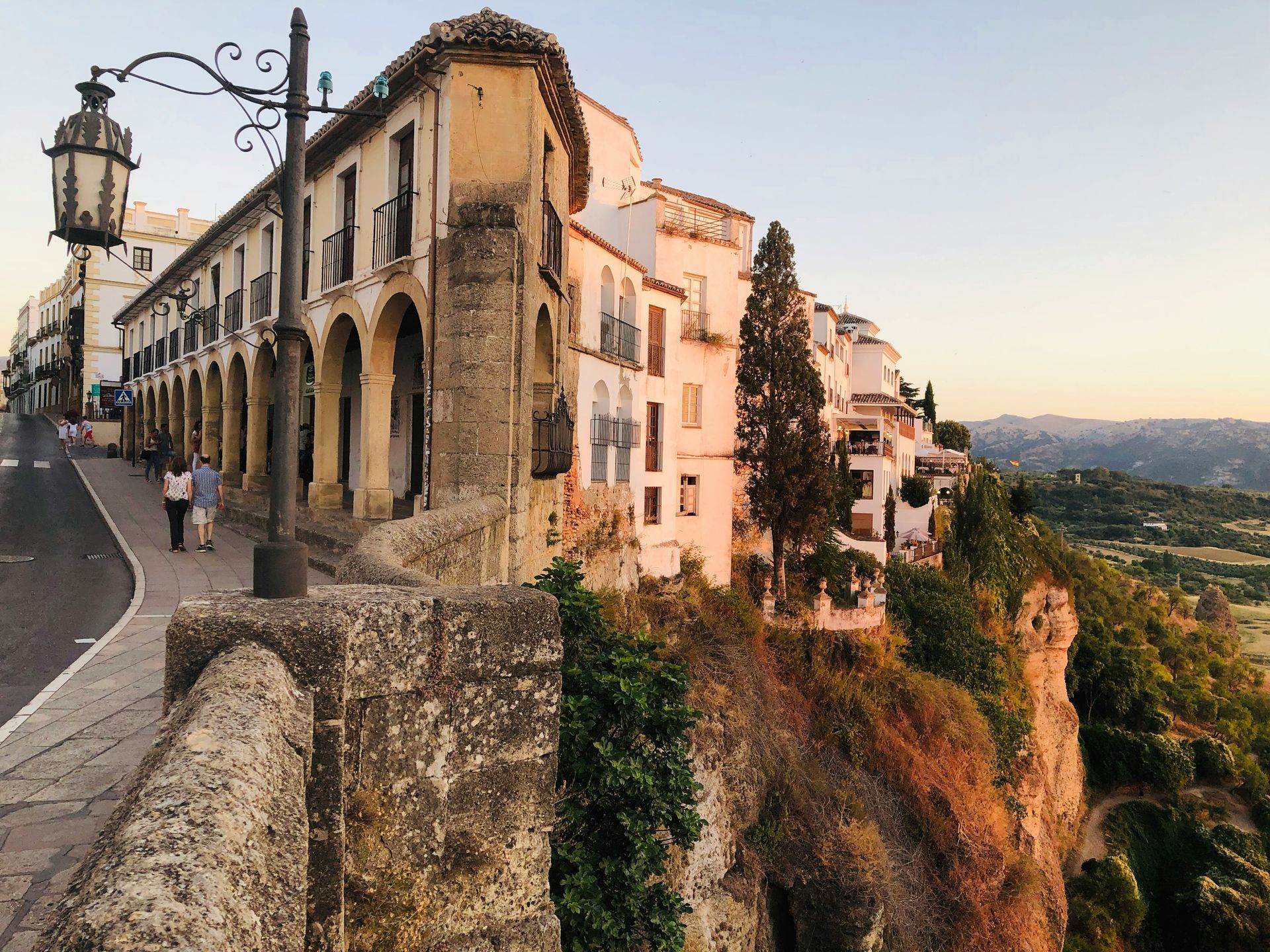 Des bâtiments bordent une falaise à Ronda, en Espagne, au coucher du soleil