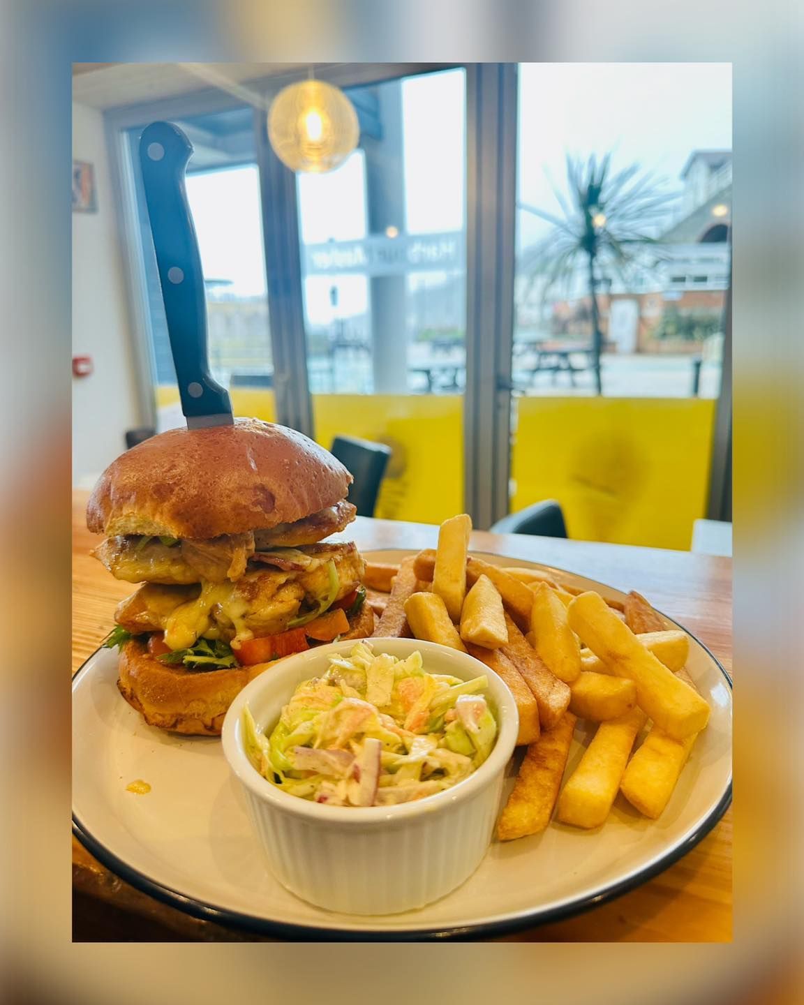 A plate of food with a hamburger and french fries on a table.