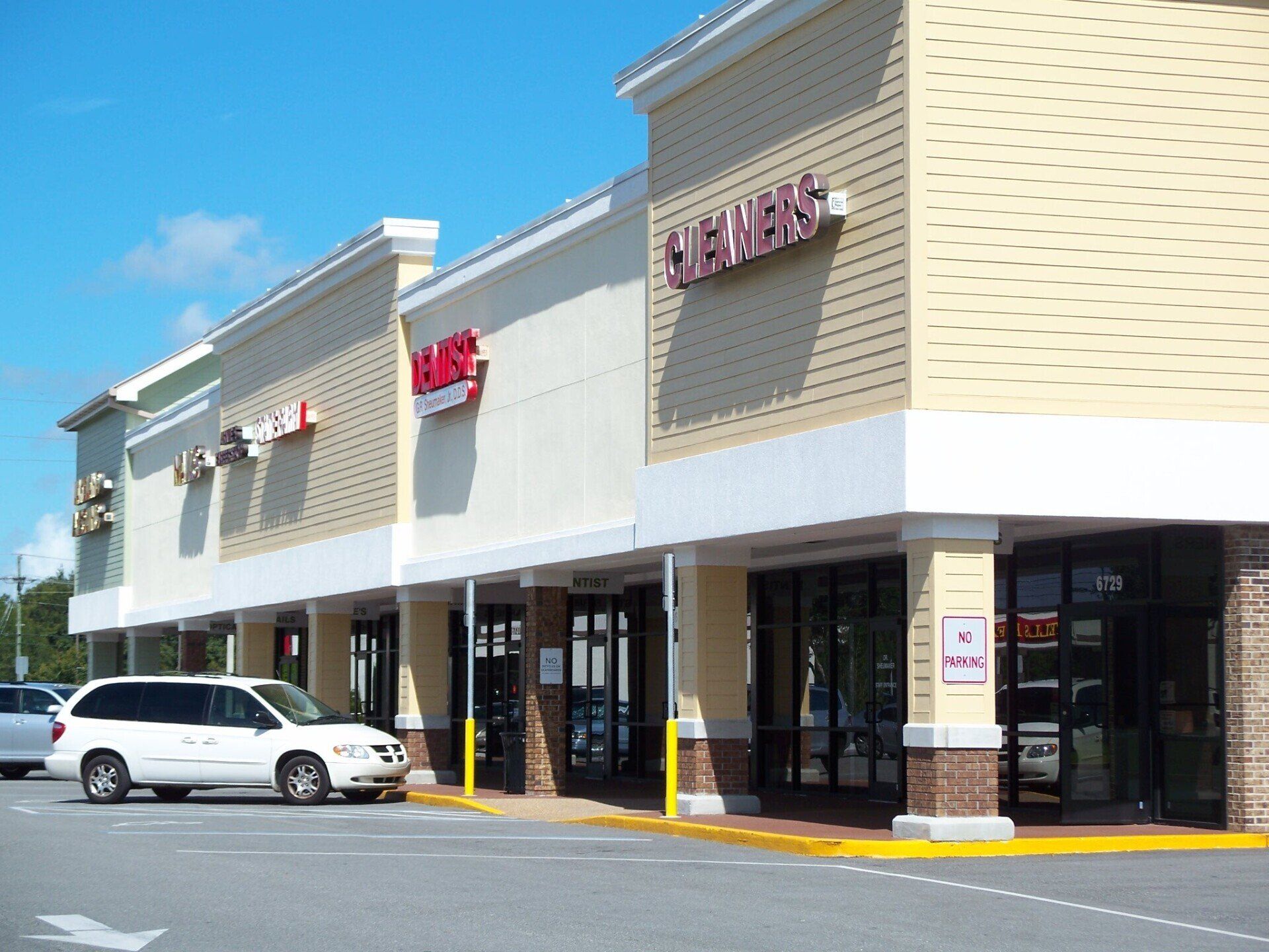 A white van is parked in front of a store called jcpenney