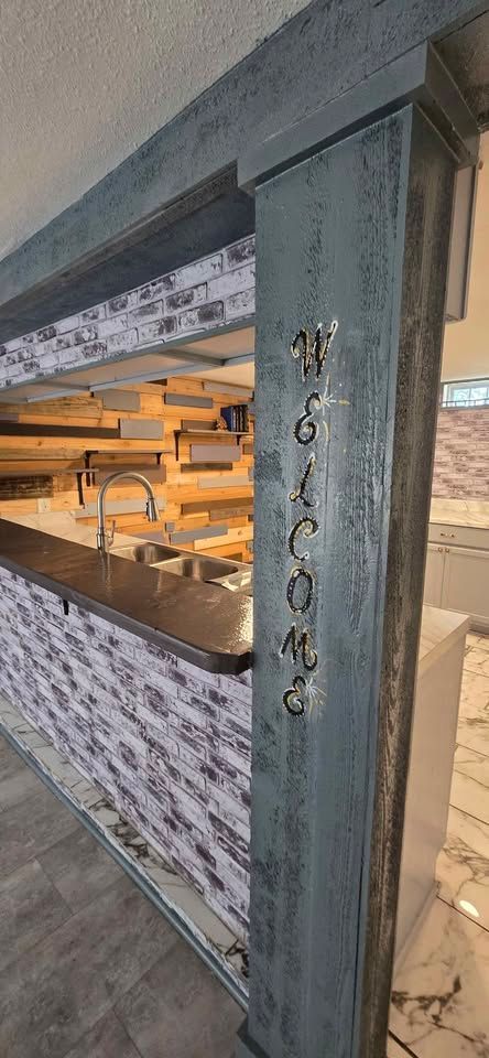 Damaged storefront column with exposed interior shelving and broken mosaic exterior paneling