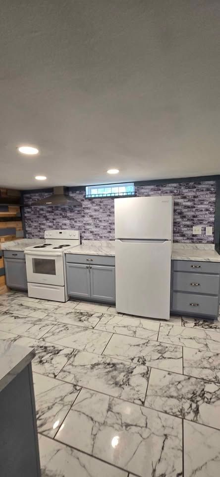 Modern kitchen with white appliances, gray cabinets, marble floor, and purple tile backsplash