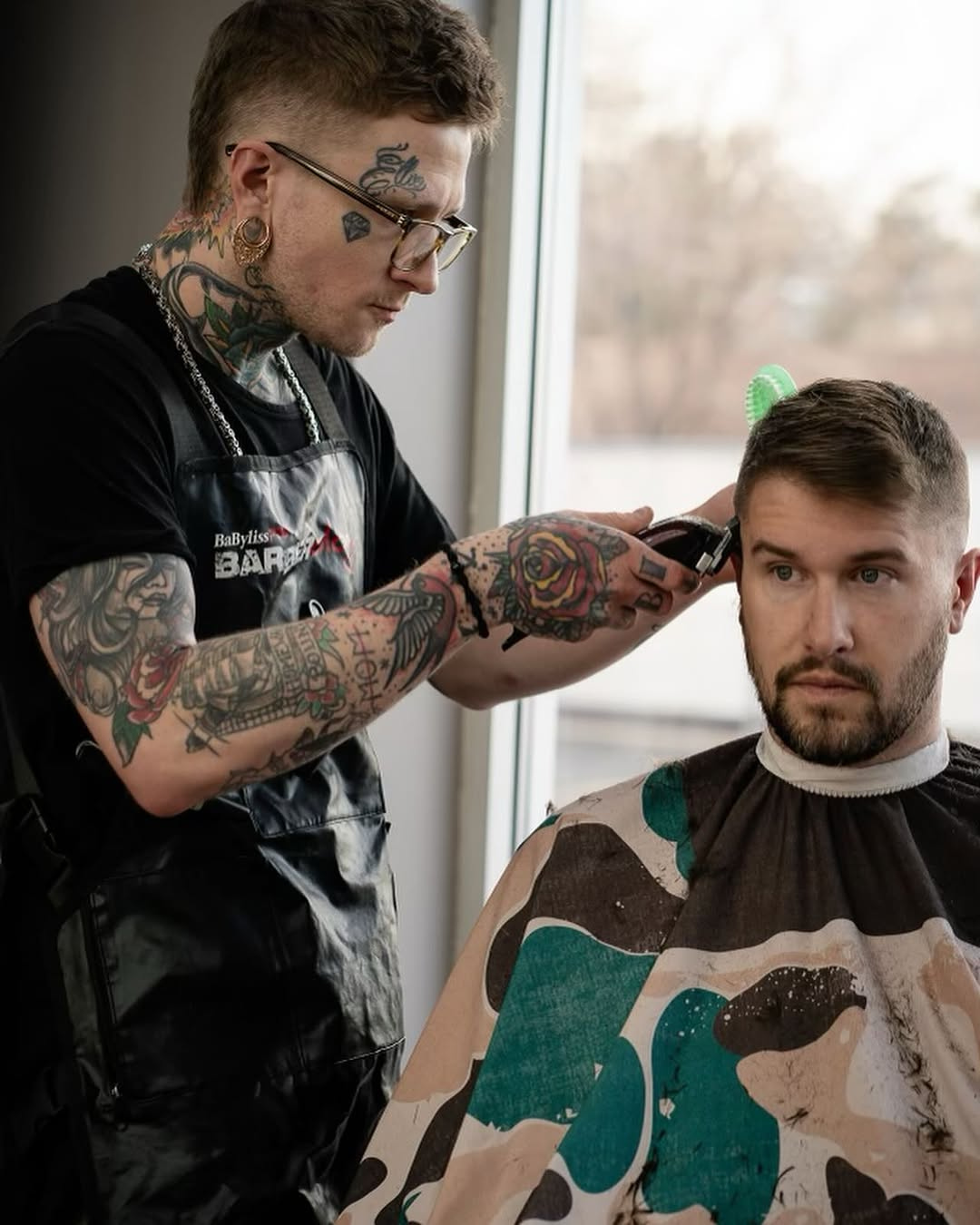 A group of men are getting their hair cut at a barber shop.