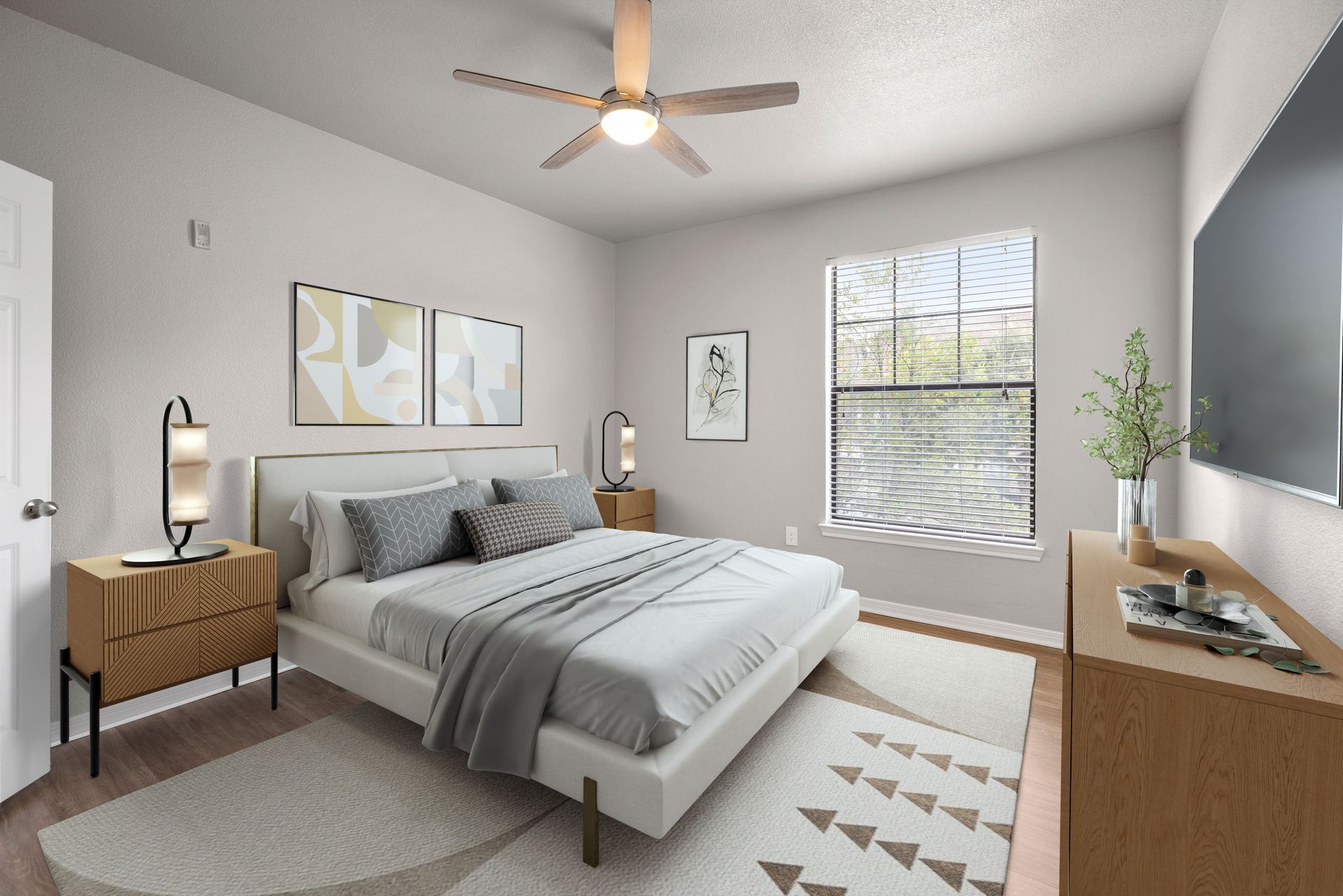 Bright modern bedroom with gray bedding, wood furniture, ceiling fan, and window blinds