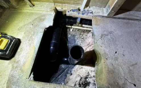 GTZ Plumbing Service LLC - A hole in the floor with a pipe coming out of it.