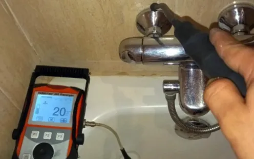 GTZ Plumbing Service LLC - A person is measuring a faucet with a device that says 20 on the screen