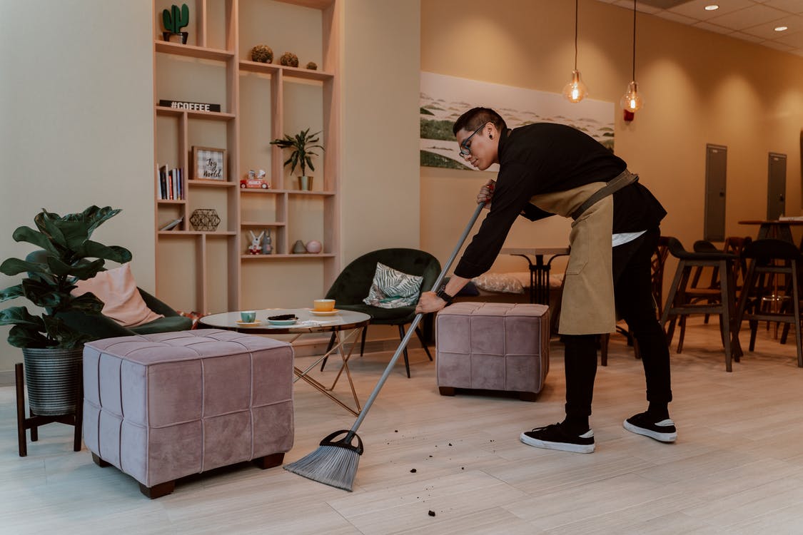 waiter sweeping the floor