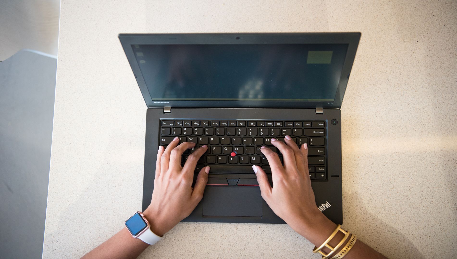 Photo of a laptop from above looking at two hands on keyboard of laptop
