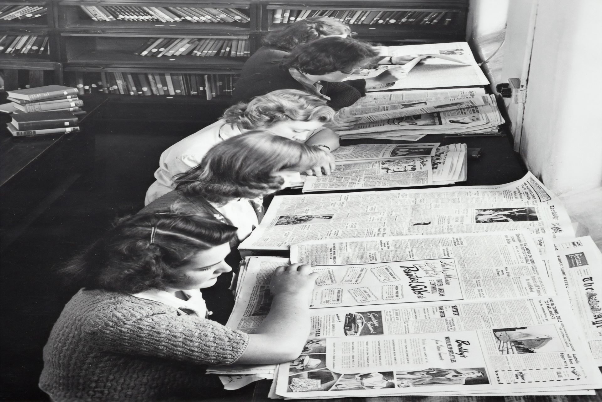 Photo of a group of women reading a newspaper
