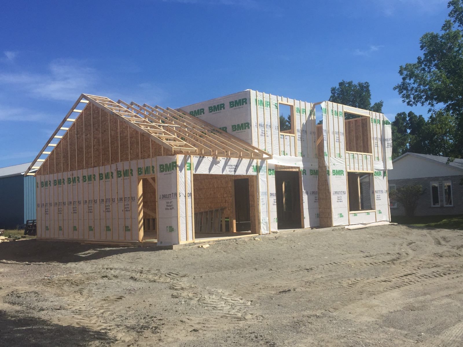 Une maison est en construction au milieu d un champ de terre.