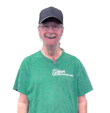 Person wearing a green t-shirt and baseball cap smiles at the camera.
