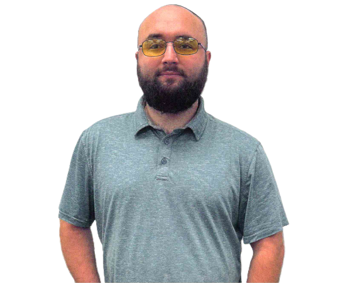 Bald man with a beard wearing yellow-tinted glasses and a gray polo shirt.