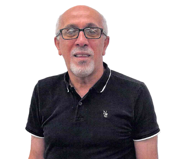 Man with glasses and white goatee, wearing a black polo shirt, smiling at camera.