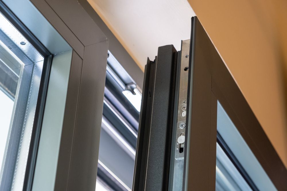 A Close-Up of A Dark Metal Folding Window Frame — Downs Window Renewals in Harristown, QLD