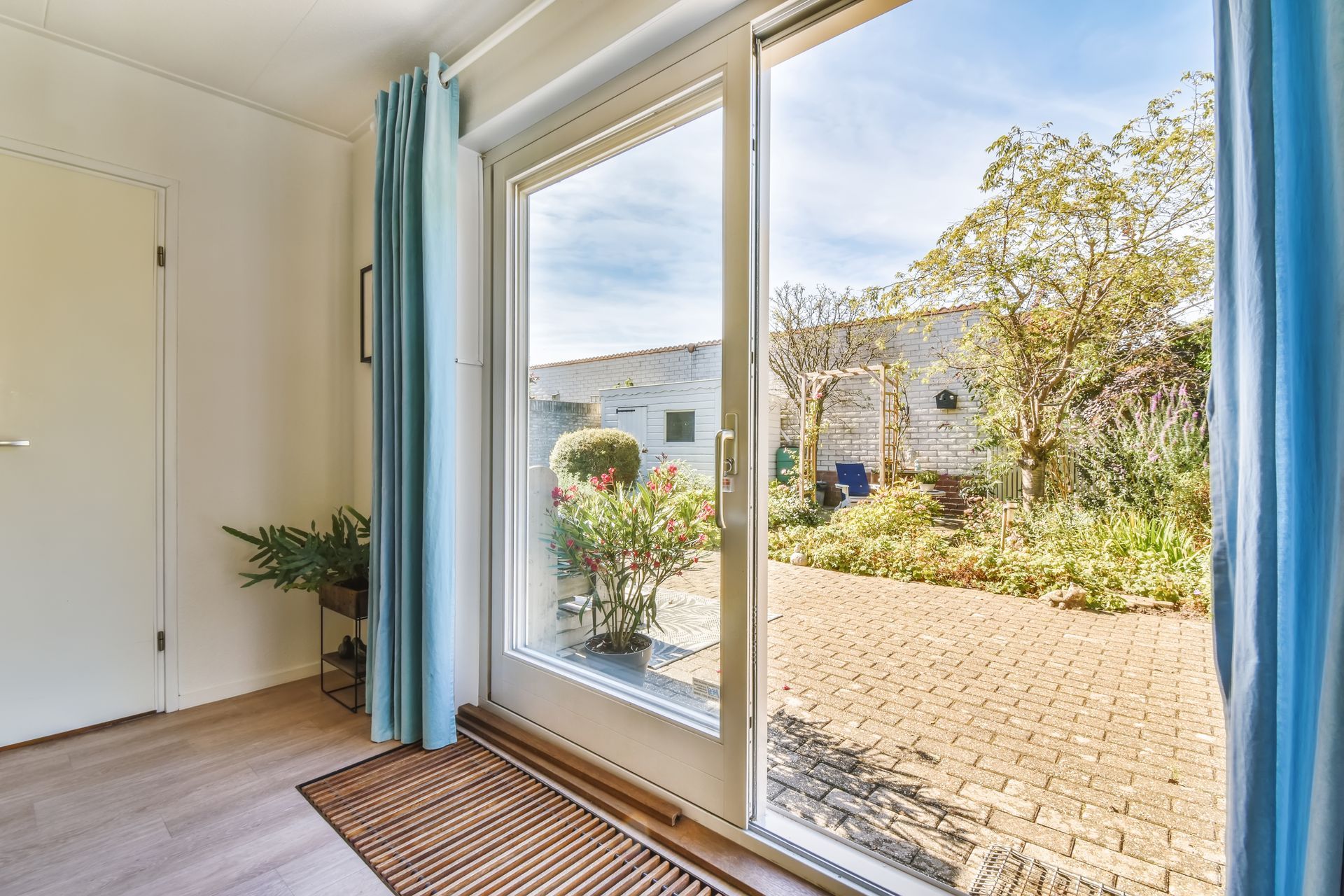 A Sliding Glass Door Opens to A Brick Patio and A Yard — Downs Window Renewals in Harristown, QLD