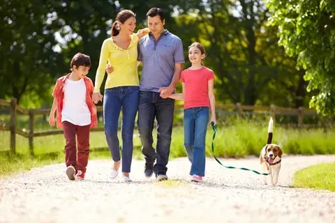 A family is walking a dog on a leash.