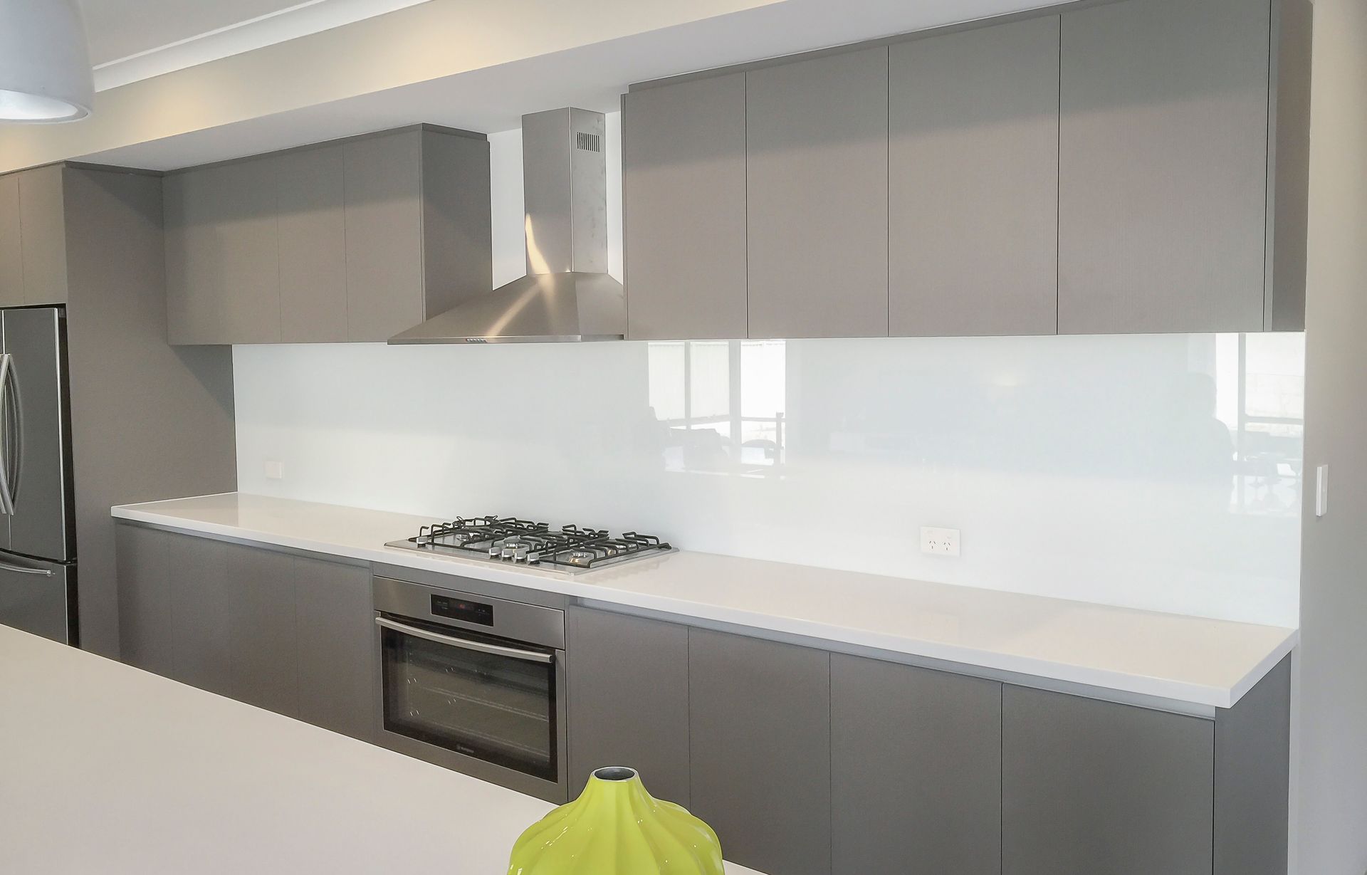 a kitchen with gray cabinets and white counter tops