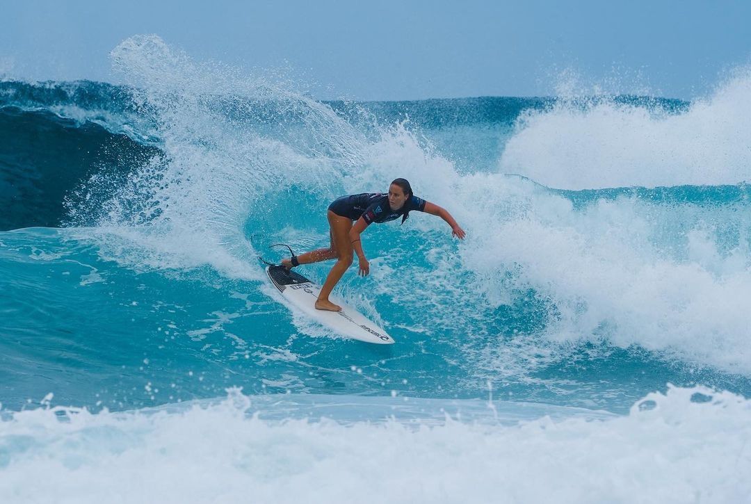 Surfer riding a wave in cabarete sosua on a turquoise ocean with white spray