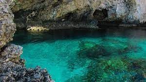 Cabarete cave with clear turquoise water and rugged stone walls