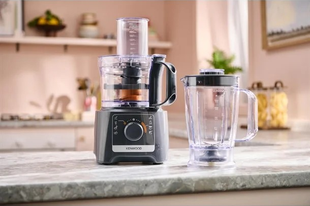 A food processor and blender are sitting on a counter in a kitchen.