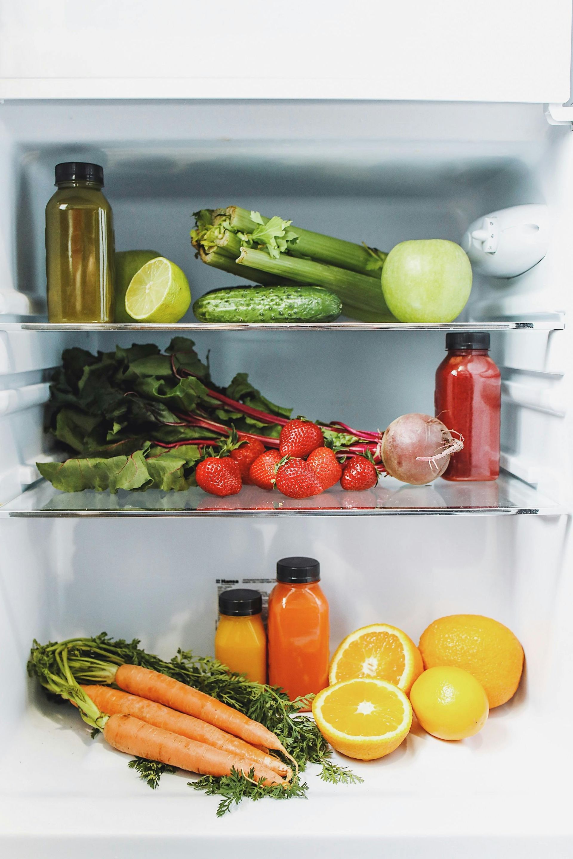Refrigerator filled with various fresh produce and juices.