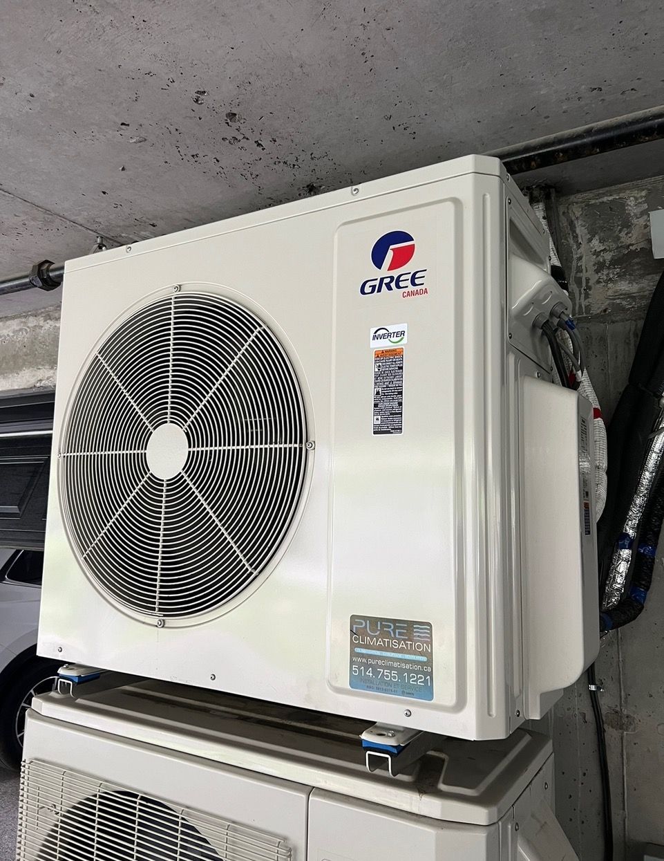 Un climatiseur gree est placé au sommet d'une pile d'autres climatiseurs.