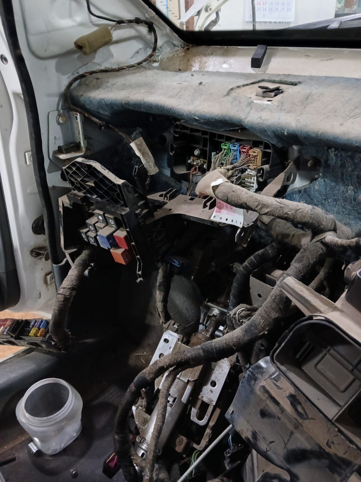 Interior del vehículo dañado con cableado expuesto y componentes del salpicadero desmontados.