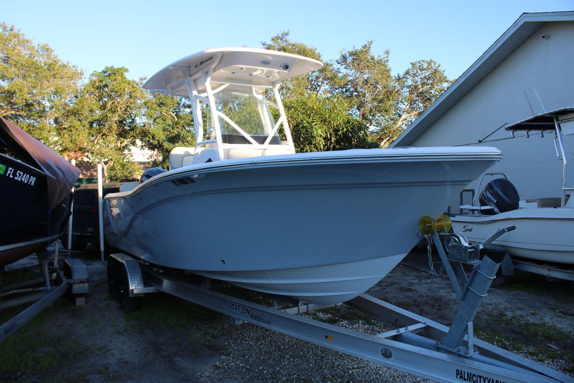 A white boat is docked at a marina on a sunny day