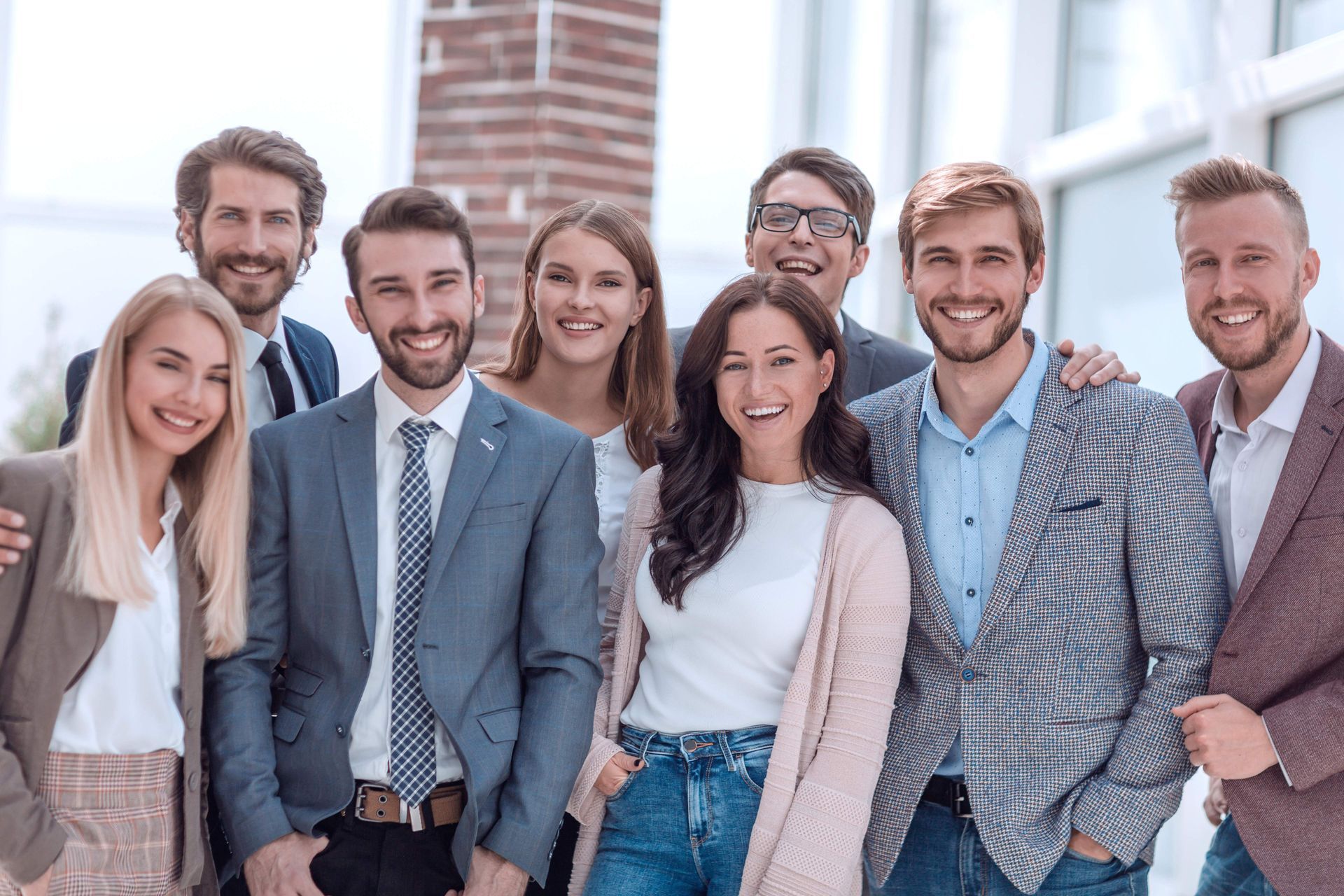 Group of smiling professionals posing together indoors.