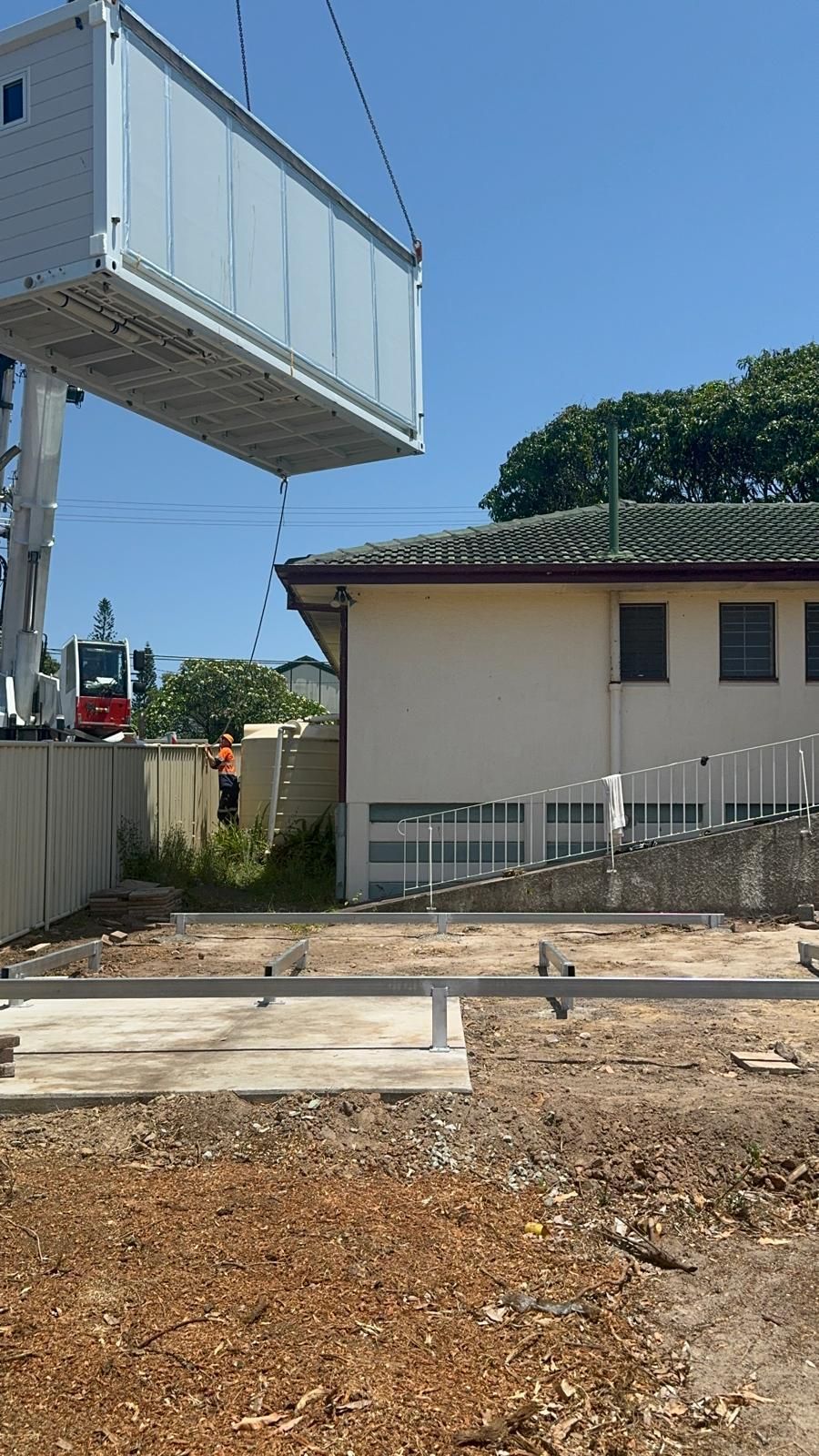 Crane Lifting a Rectangular Container Near a Building — Expandable Housing in Inala, QLD