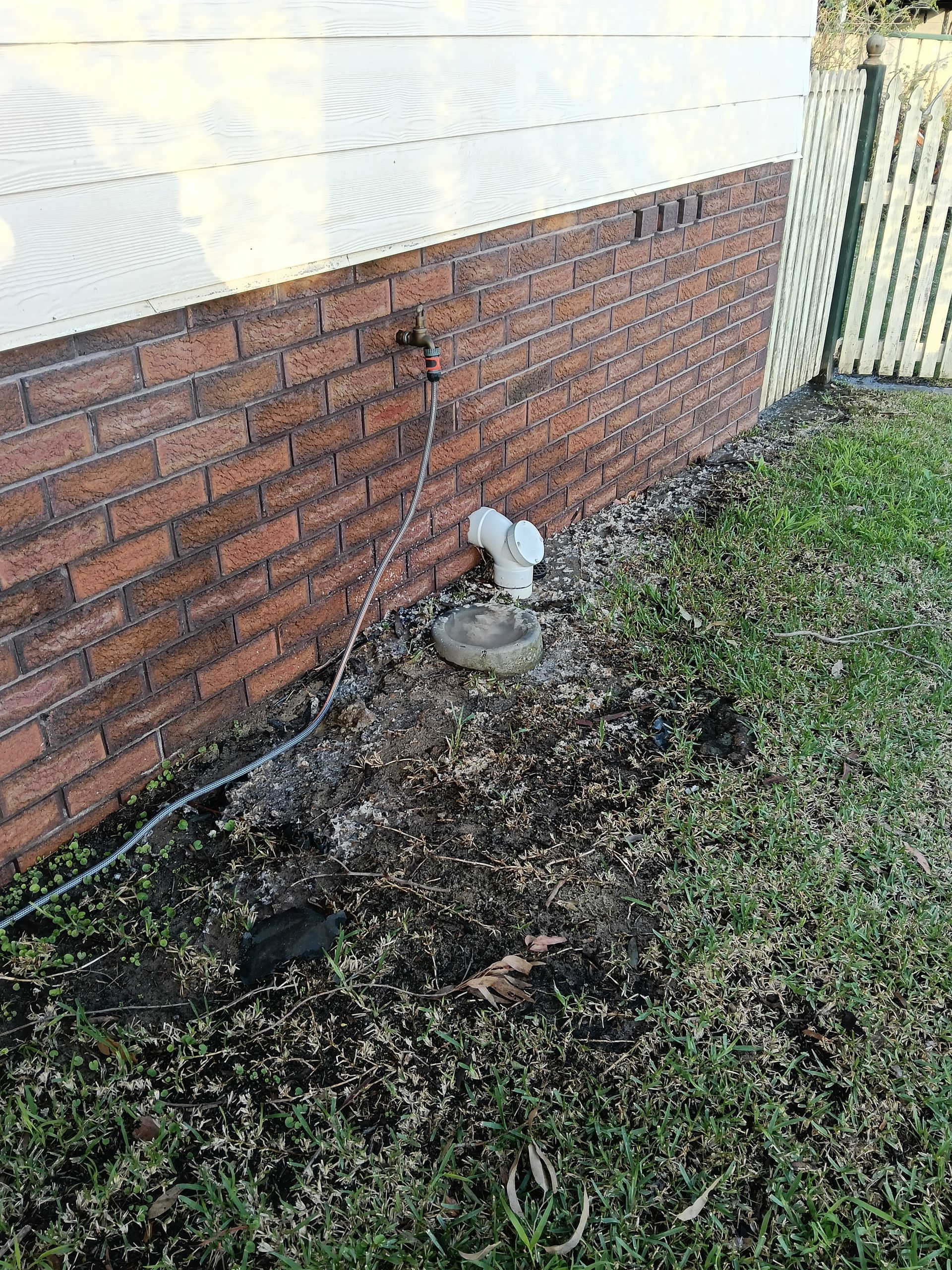Outdoor faucet on brick wall above a small basin — Huddo's Plumbing Service in Wallalong, NSW