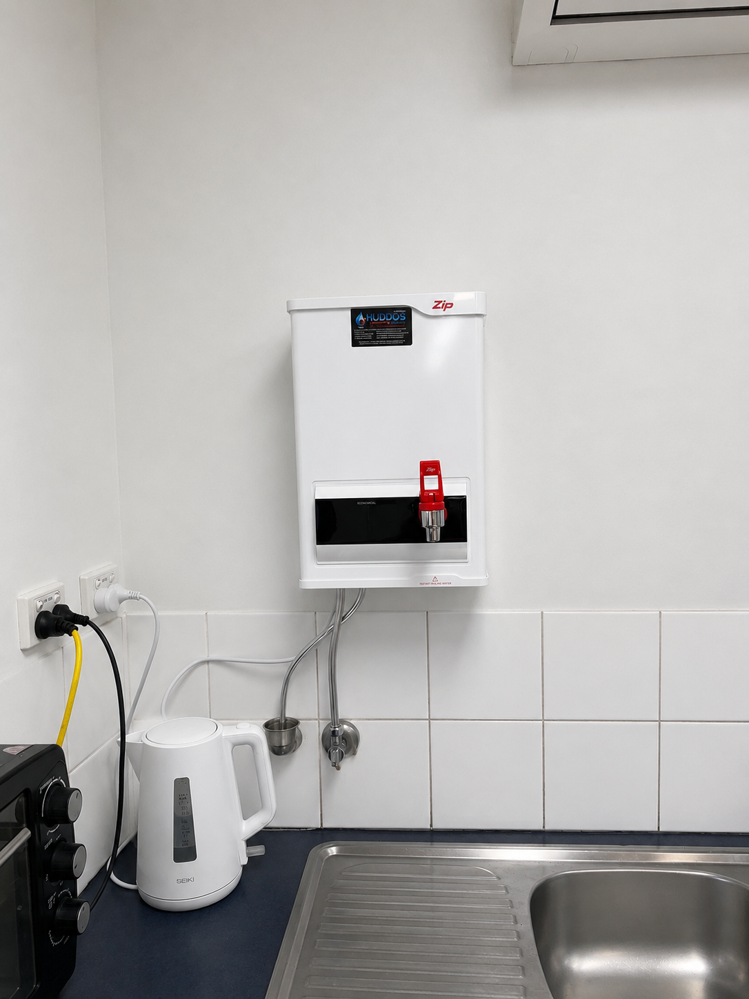 Wall-mounted White SOAP Dispenser Above a Stainless-steel Sink — Huddo's Plumbing Service in Wallalong, NSW