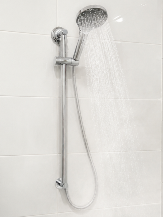 Stainless steel shower with handheld sprayer spraying water in a white tiled bathroom — Huddo's Plumbing Service in Wallalong, NSW