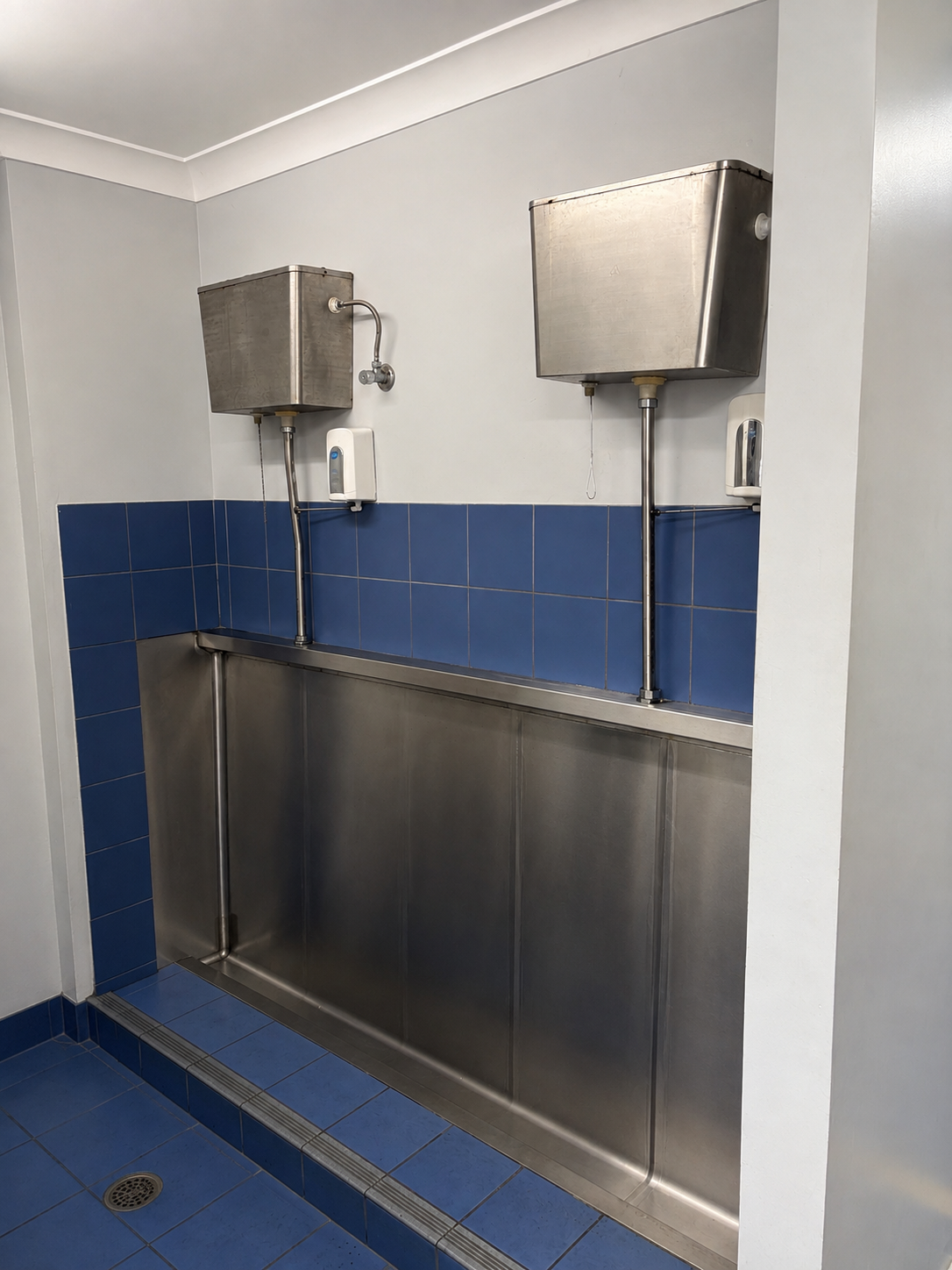 Public Restroom With Stainless Steel Urinals — Huddo's Plumbing Service in Wallalong, NSW