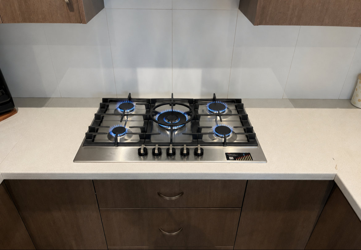 Built-in Gas Cooktop On A White Kitchen Countertop — Huddo's Plumbing Service in Wallalong, NSW