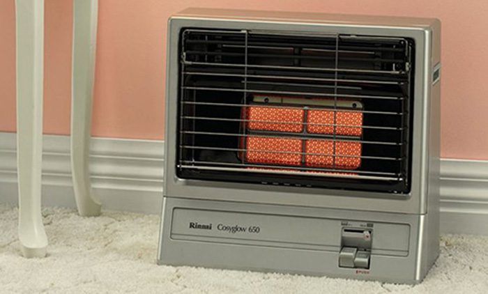 Small Grey Space Heater With Orange Glow Behind Black Grille — Huddo's Plumbing Service in Wallalong, NSW