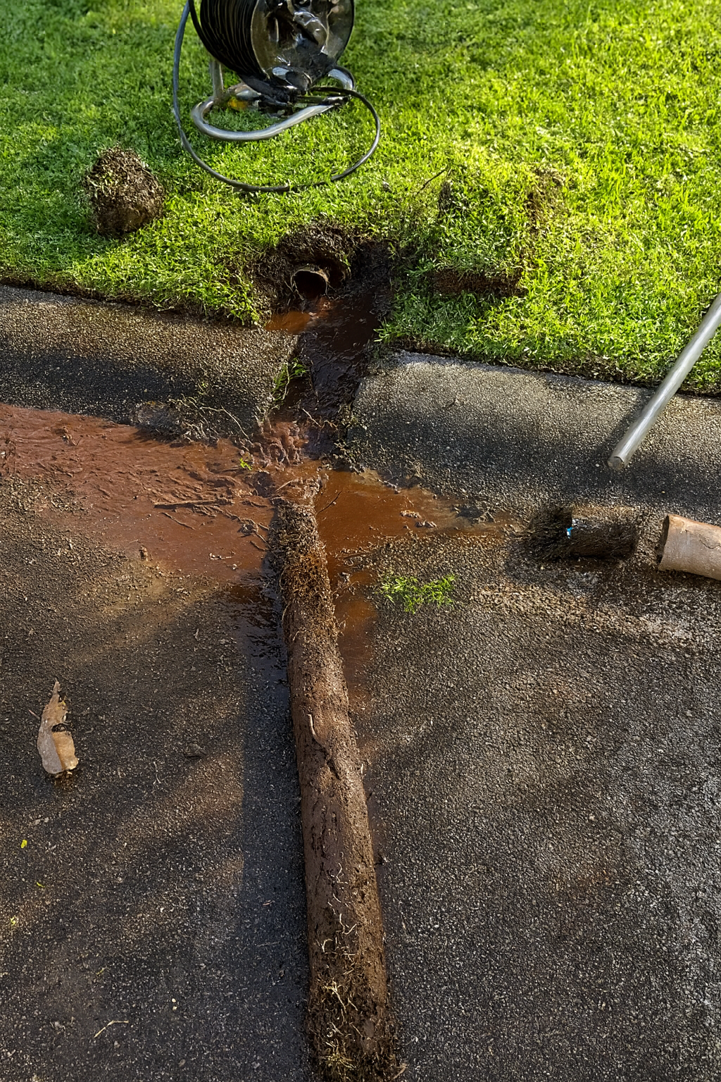 Concrete Drain With Rusty Interior, Surrounded by Concrete and Grass — Huddo's Plumbing Service in Wallalong, NSW